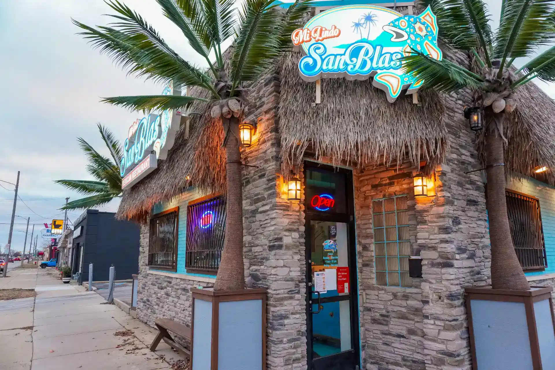 Exterior view of Mi Lindo San Blas restaurant with palm trees and tropical decor.